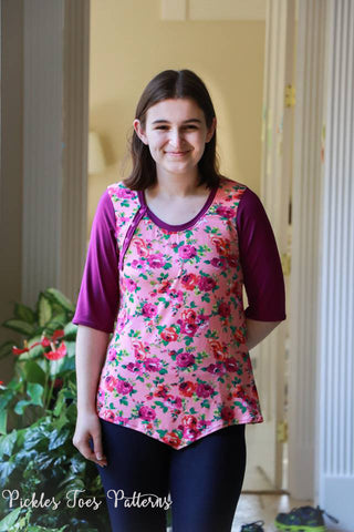 Woman modeling Hope top length with one placket on the top, v hem and pink floral fabric.