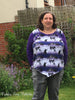 Woman modeling top length of Hope Pattern fabric is a purple and white stripe with purple sleeves.